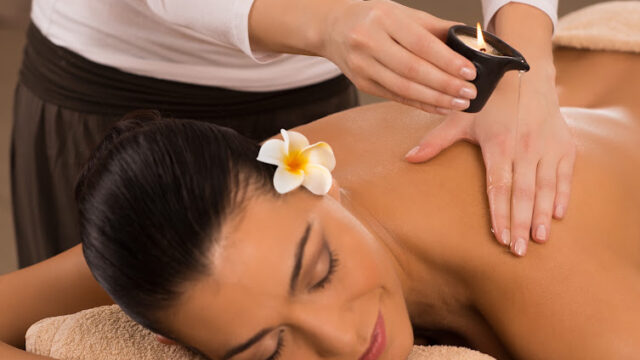Relaxed Woman Receiving A Candle Massage